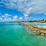 Malerischer Strand mit klarem Wasser, Sandstrand und Palmen, ideal für Erholung und Wassersport, perfekt für Urlaubsfotos und Entspannung.