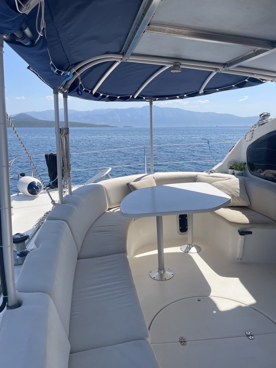Relaxing outdoor seating area on a private luxury catamaran with panoramic ocean views. Perfect for enjoying the sea breeze and sunshine during a charter with SV Monika.